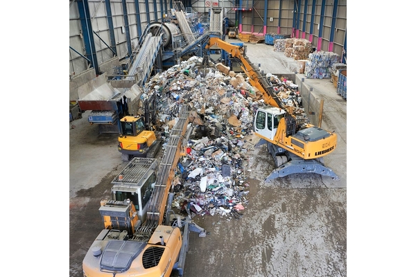 Three crains inside a recycling facility.